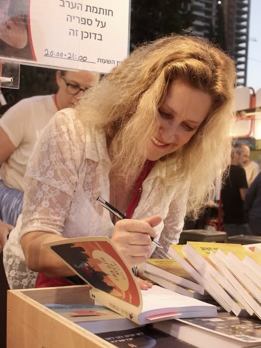 מיכל בראון חותמת על ספרים בשבוע הספר
